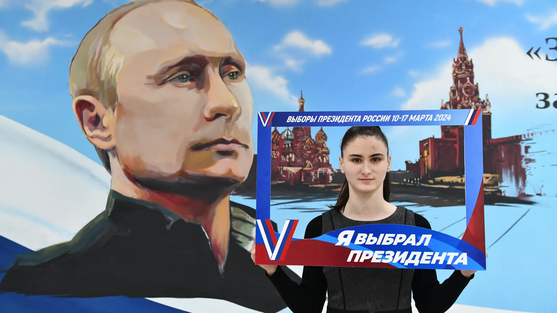 Donetsk (Russian Federation), 15/03/2024.- A woman poses by a portrait of Russian President Vladimir Putin holding a sign reading 'ÄòI elected a President'Äô after voting in presidential elections at a polling station in Donetsk, Russian controlled part of Ukraine, 15 March 2024. The Federation Council has scheduled presidential elections for March 17, 2024. Voting will last three days: March 15, 16 and 17. Four candidates registered by the Central Election Commission of the Russian Federatio...