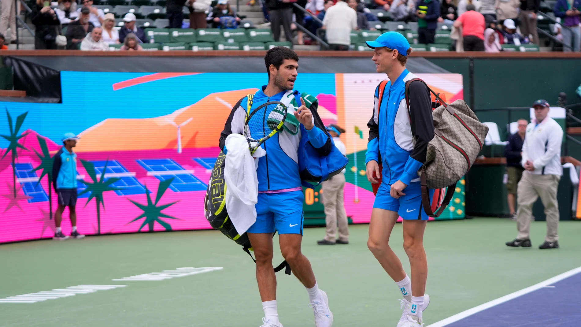 Carlos Alcaraz, of Spain, left, talks with Jannik Sinner, of Italy, as they walk off the court during a rain delay in their semifinal match at the BNP Paribas Open tennis tournament, Saturday, March 16, 2024, in Indian Wells, Calif. (AP Photo/Mark J. Terrill)