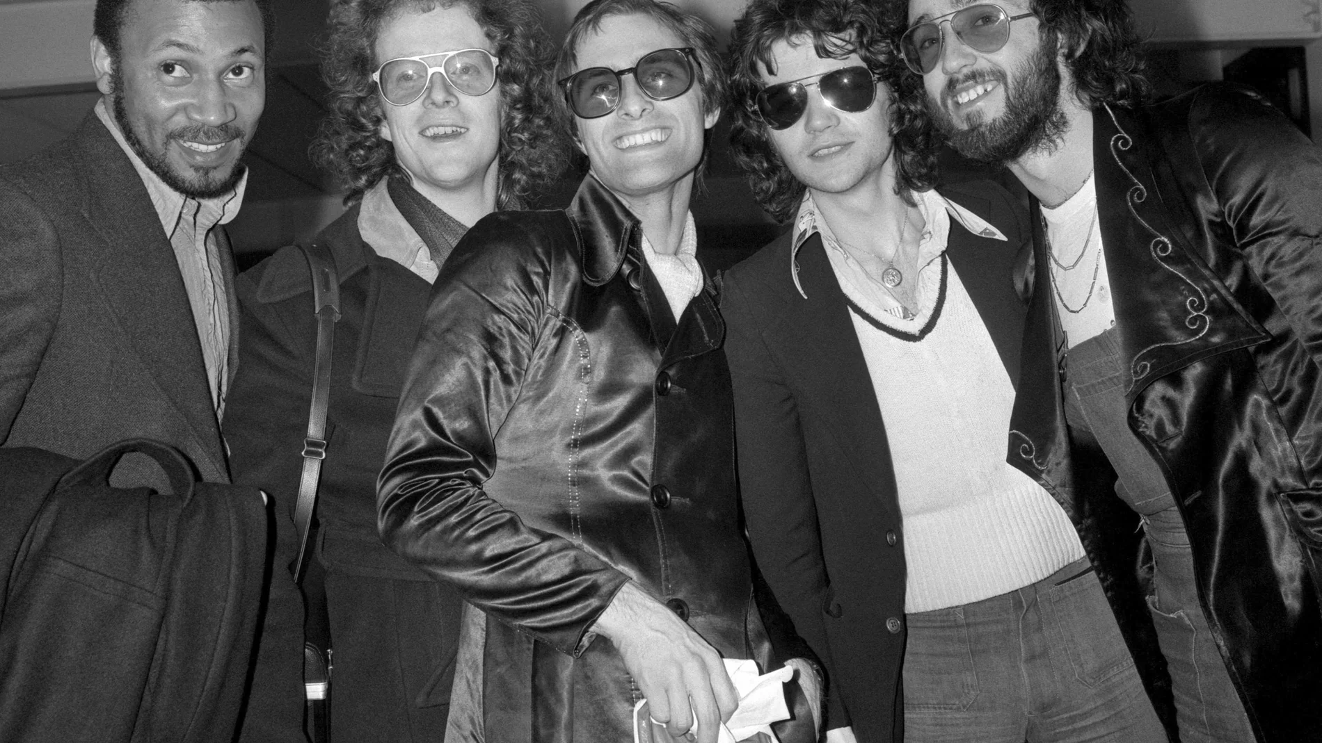 FILE - Steve Harley, center, and Cockney Rebel at London's Heathrow airport, Feb. 26, 1975, on their arrival from America. British musician Steve Harley, whose band Cockney Rebel had a huge hit with the song “Make Me Smile (Come Up and See Me),” has died. He was 73. Harley’s family said Sunday March 17, 2024 he had “passed away peacefully at home, with his family by his side.” (PA via AP)