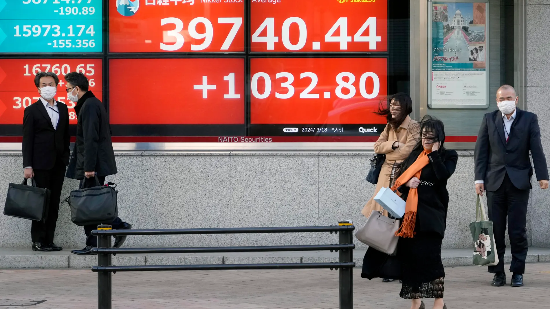 Tokyo (Japan), 18/03/2024.- People stand in front of a stock market indicator board in Tokyo, Japan, 18 March 2024. Tokyo stocks rebounded sharply gaining more than two percent on export-related companies such as automobiles, whose earnings are expected to improve as the yen weakened. The 225-issue Nikkei Stock Average soared 1,032.80 points, or 2.67 percent, to close at 39,740.44. (Japón, Tokio) EFE/EPA/FRANCK ROBICHON