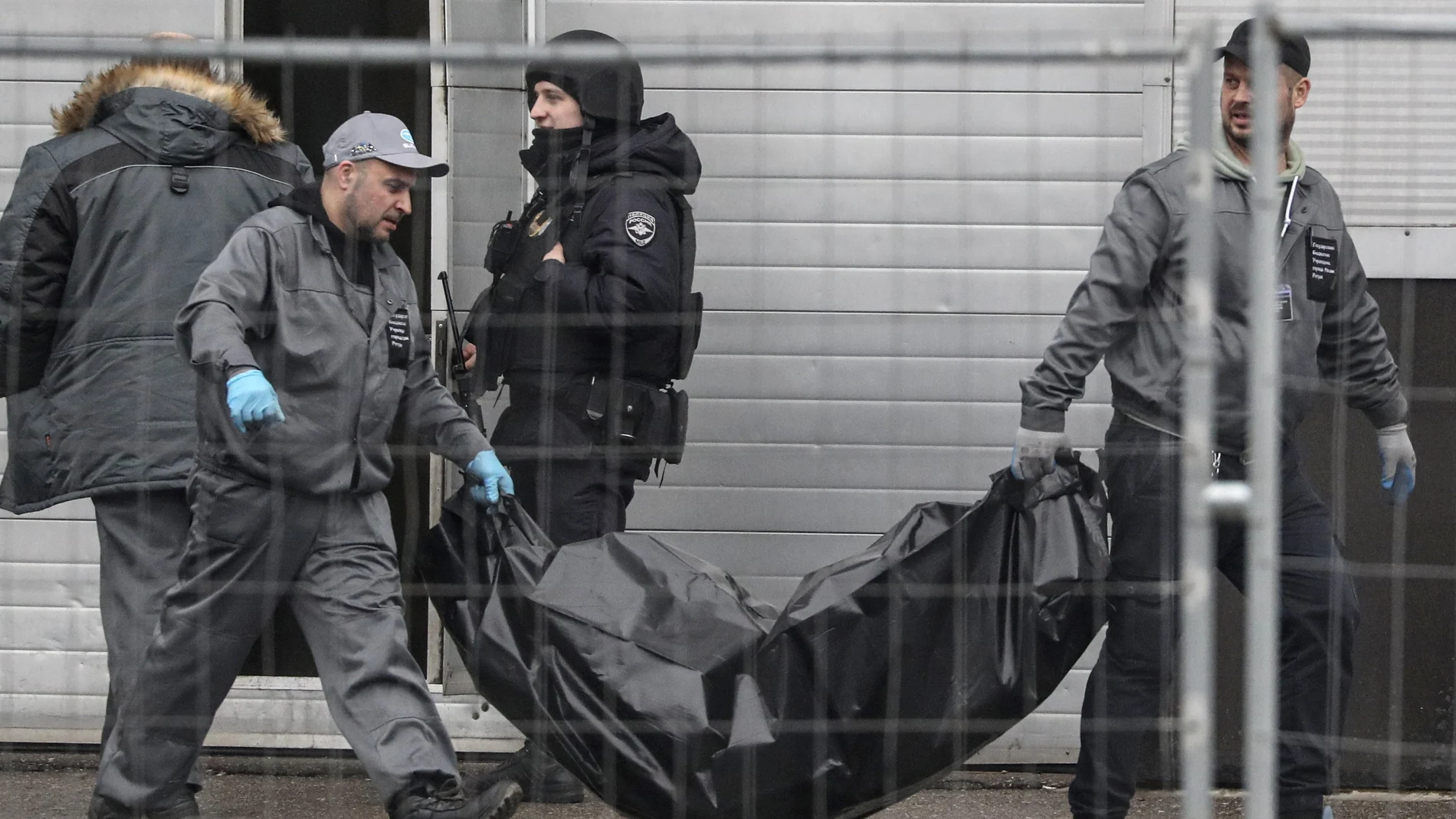 Operarios sanitarios cargan con uno de los cuerpos de las víctimas del tiroteo en la sala de conciertos del Crocus City Hall en Krasnogorsk, a las afueras de Moscú, Rusia este sábado.