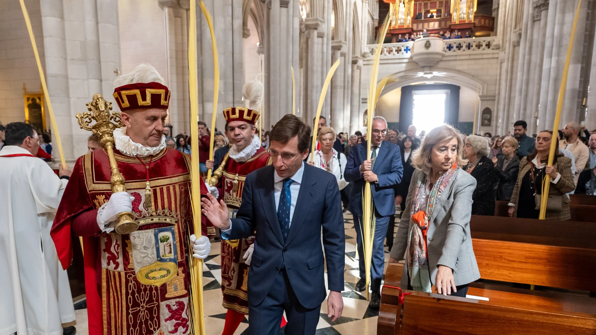 El alcalde de Madrid, José Luis Martínez-Almeida (c), junto a otros miembros del equipo de Gobierno y representantes de los grupos municipales, asiste a la bendición de las palmas y a la eucaristía del Domingo de Ramos oficiada por el arzobispo de Madrid, cardenal José Cobo, este domingo en la catedral de la Almudena.