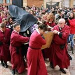 Penitentes la Cofradía del Santo Cristo del Desenclavo de León protegen la talla de la lluvia