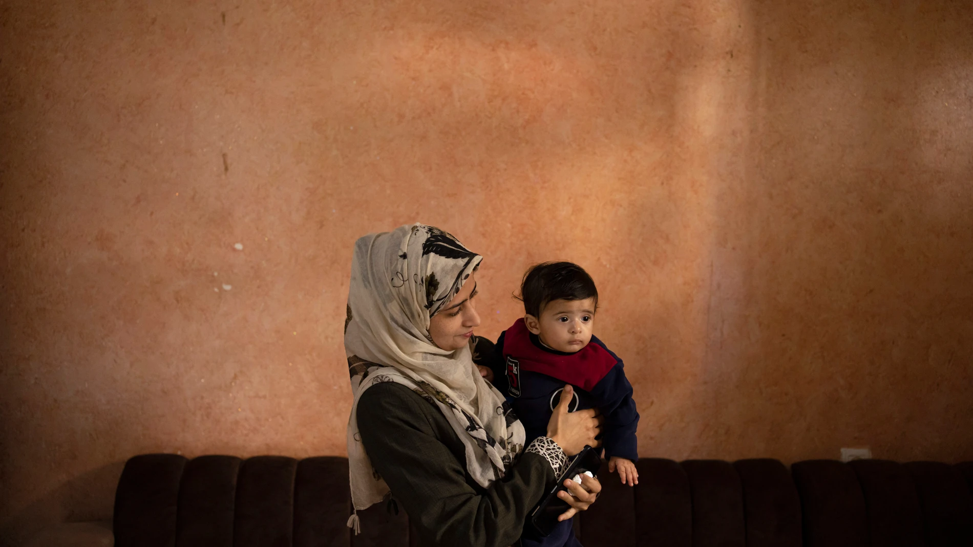 Amal Al-Taweel poses for a photo with her baby Ali at her family home in Zawaida, central Gaza Strip, Friday, April 5, 2024. Ali was born Oct. 7, the day the Israel-Hamas war erupted. Mothers who gave birth in the Gaza Strip that day fret that their 6-month-old babies have known nothing but brutal war, characterized by a lack of baby food, unsanitary shelter conditions and the crashing of airstrikes. (AP Photo/Fatima Shbair)