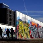 Varias personas caminan junto a la East Side Gallery, el más largo tramo que queda en pie del muro, en Berlín, Alemania.