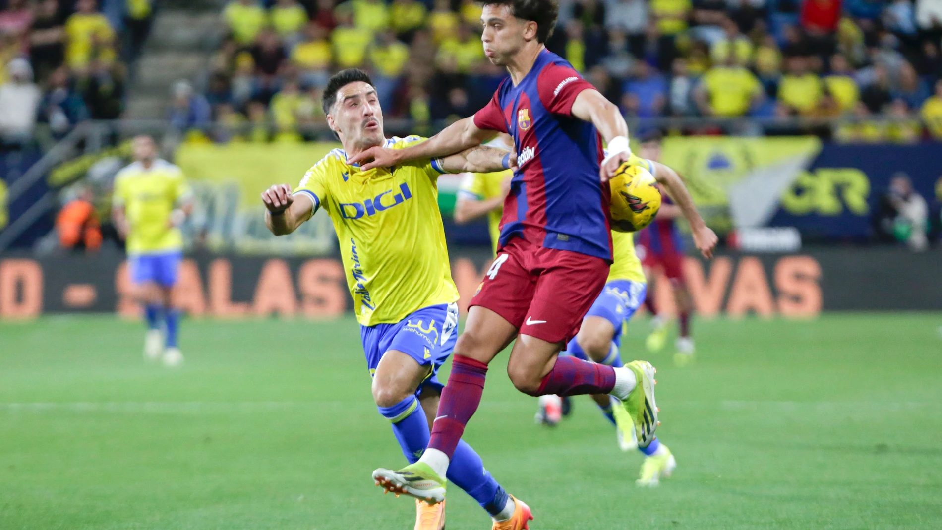 CÁDIZ, 13/04/2024.- El delantero del FC Barcelona Joao Félix (d) lucha por el balón con el el defensa del Cádiz CF Iza, durante el partido de Liga que enfrenta al Cádiz CF y al Barcelona CF en el estadio Nuevo Mirandilla, este sábado. EFE/Román Ríos.