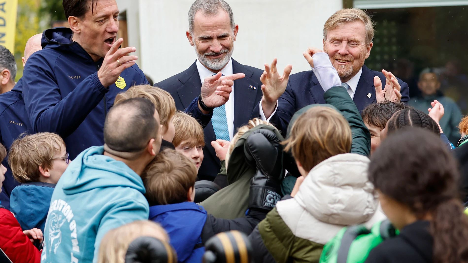 ÁMSTERDAM (PAÍSES BAJOS), 17/04/2024.- El rey de España, Felipe VI (c), y el rey Guillermo Alejandro de los Países Bajos (d), acompañados por el director de la Fundación Cruyff, Niels Meijer (i), conversan con un grupo de niños durante su visita a la institución, dedicada a facilitar la actividad deportiva a niños con discapacidad o de barrios desfavorecidos, este miércoles en el marco de la visita de Estado de los reyes de España a los Países Bajos. EFE/ Chema Moya