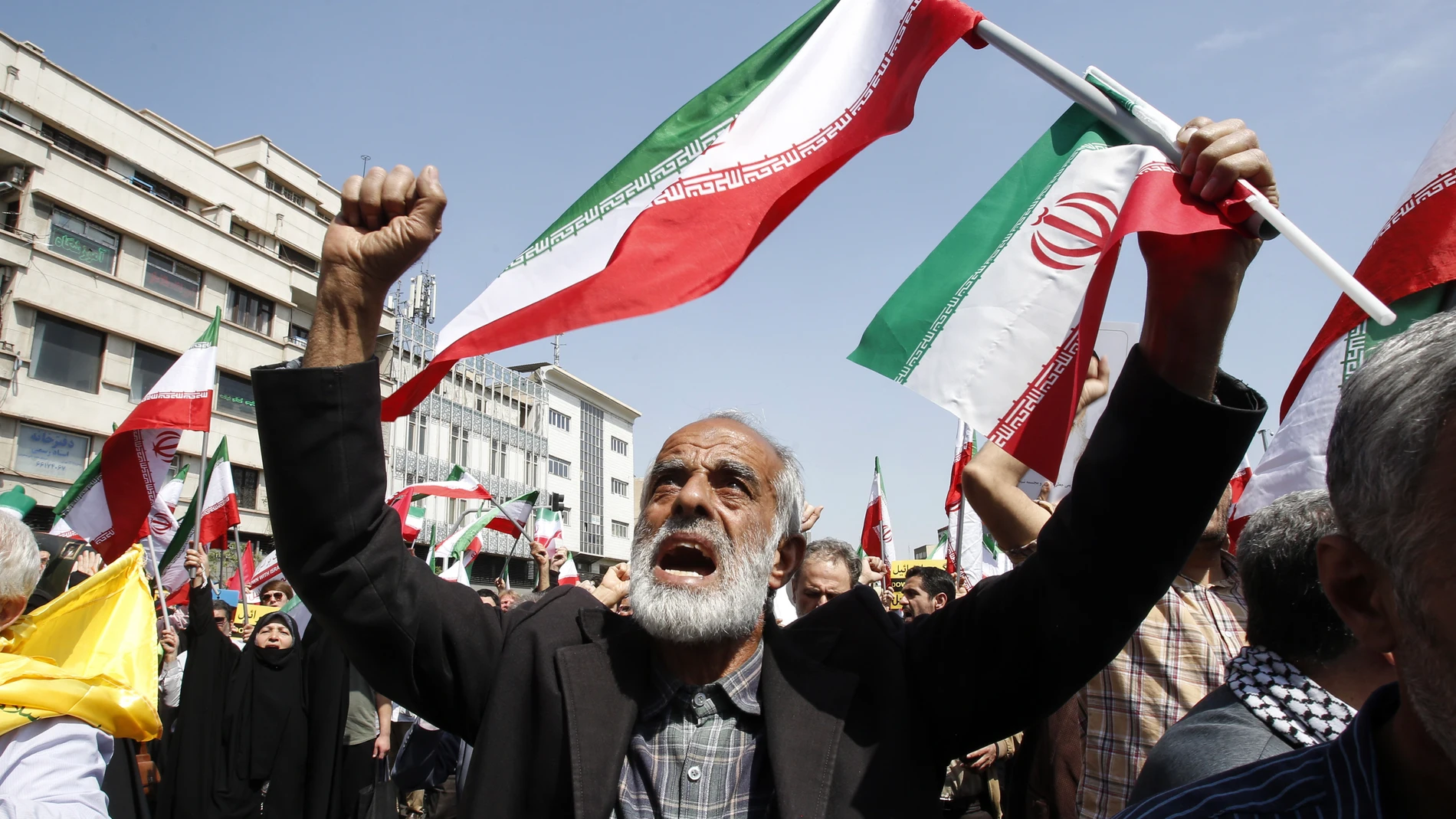 Tehran (Iran(islamic Republic Of)), 19/04/2024.- Iranians shout slogans and wave Iranian flags during an anti-Israel rally in Tehran, Iran, 19 April 2024. Iranian state media reported that three aerial objects were destroyed by air defense systems over the central city of Isfahan early morning on 19 April. The explosions come after a drone and missile attack carried by Iran's Islamic Revolutionary Guards Corps (IRGC) towards Israel on 13 April, following an airstrike on the Iranian embassy in...
