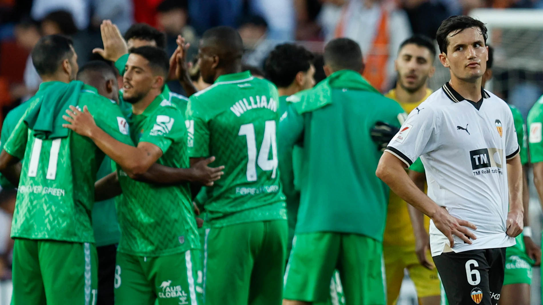 VALENCIA, 20/04/2024.- Los jugadores del Betis celebran la victoria ante la decepción del jugador del Valencia Hugo Guillamón (dcha), tras el partido de la jornada 32 de LaLiga EA Sports entre el Valencia CF y el Real Betis, disputado hoy sábado en el estadio de Mestalla de Valencia. EFE/Biel Aliño
