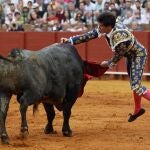 El diestro Esaú Fernández lidia el tercero de la tarde en el último festejo de la Feria de Abril, hoy domingo en la Real Maestranza de Sevilla, con toros de Miura.