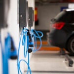 Estacionamiento y zona de recarga de coches eléctricos. Manguera y conector de cargadores. © Jesús G. Feria.