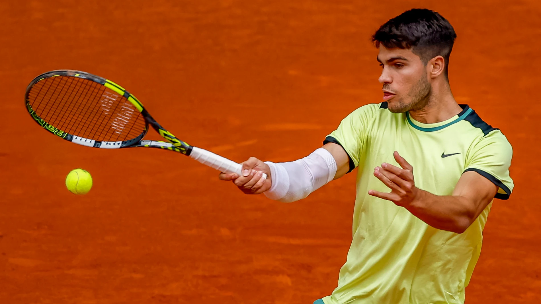 MADRID, 28/04/2024.- El tenista español Carlos Alcaraz devuelve una bola al tenista brasileño Thiago Seyboth, durante el partido de segunda ronda del Masters 1000 Mutua Madrid Open disputado este domingo en la Caja Mágica. EFE/ Daniel González