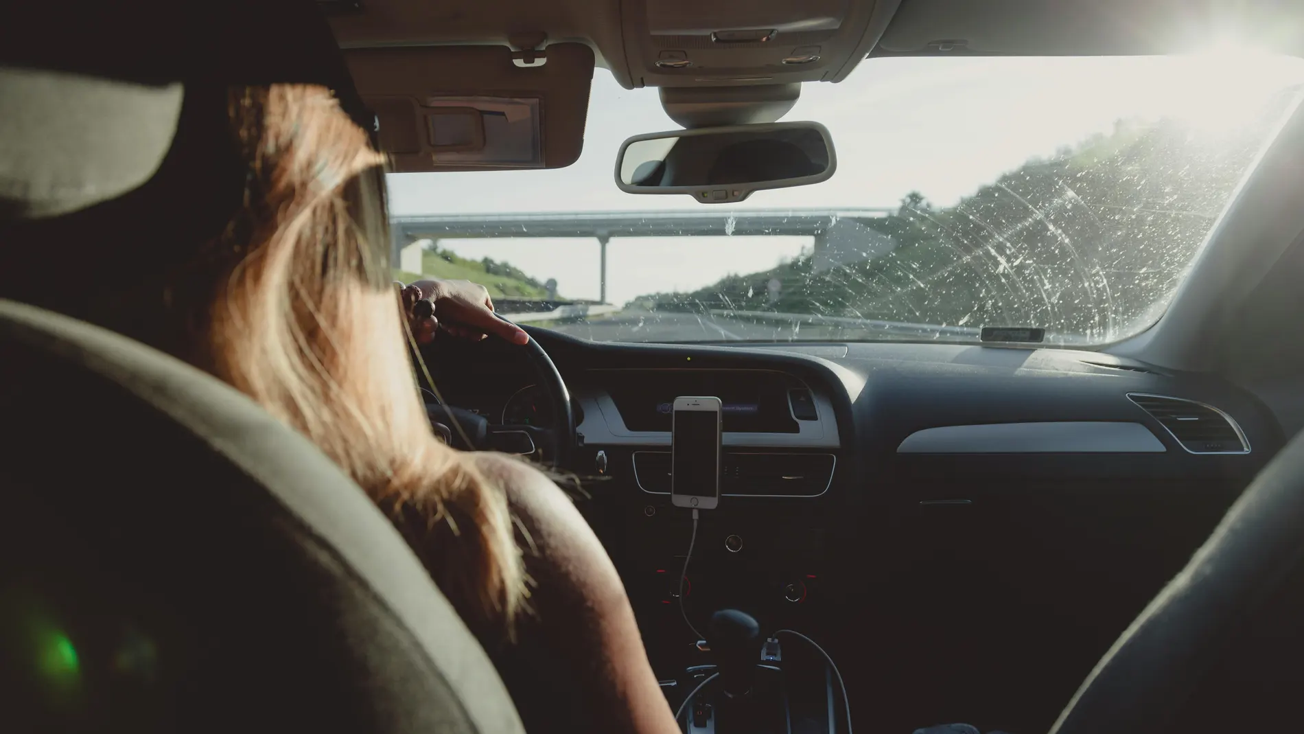 Mujer conduciendo un coche en una autopista.