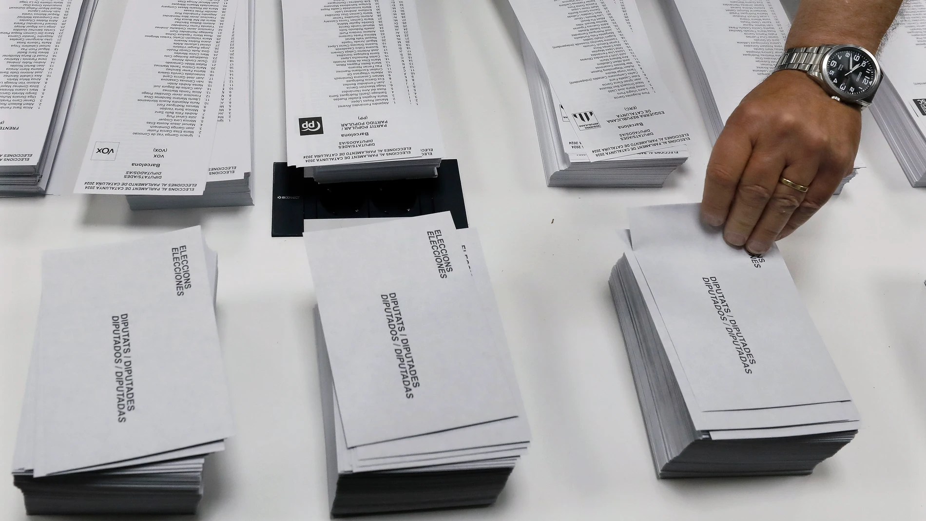 BARCELONA, 12/05/2024.-Votante recoge sobre en el colegio electoral instalado en el Instituto de Educación Continua (UPF) del barrio de L,Eixample de Barcelona, este domingo. Más de cinco millones de ciudadanos están llamados este domingo a las urnas en las elecciones catalanas, en las que parte como favorito el socialista Salvador Illa y en las que se dirime si la gobernabilidad sigue en base a la suma de los partidos independentistas. EFE/Andreu Dalmau