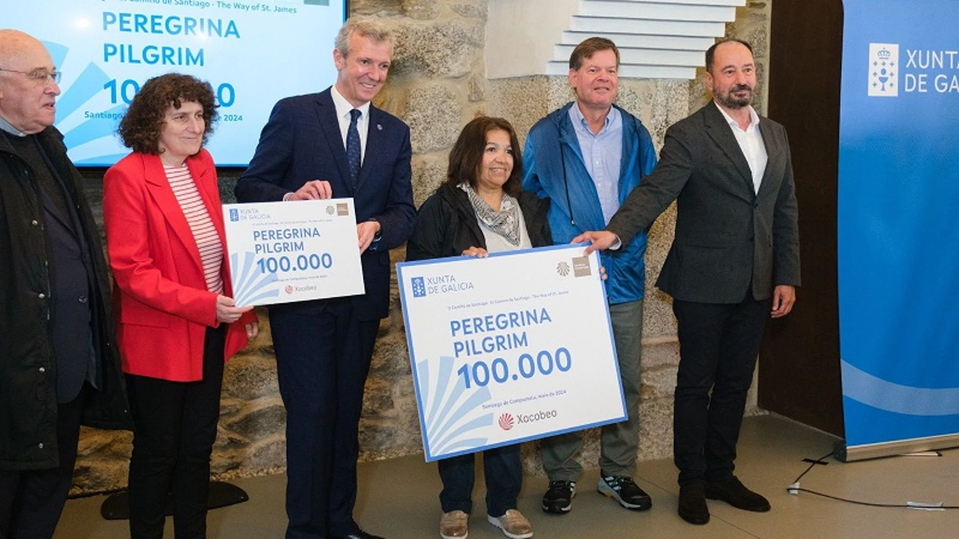 Alfonso Rueda y la alcaldesea de Santiago Goretti Sanmartín (izquierda) acompañan a Milagros Miní (derecha), peregrina 100.000 de 2024.