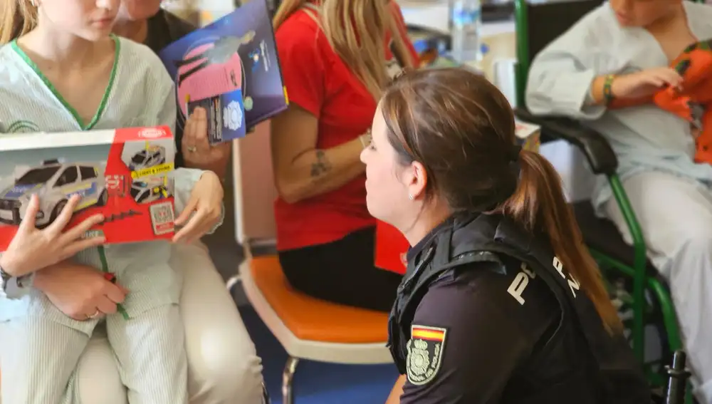 Una agente nacional entrega un regalo a una niña