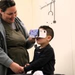 Aran coge de la mano a su madre mientras se prepara para su intervención visualizando el vídeo de realidad virtual de Nixi