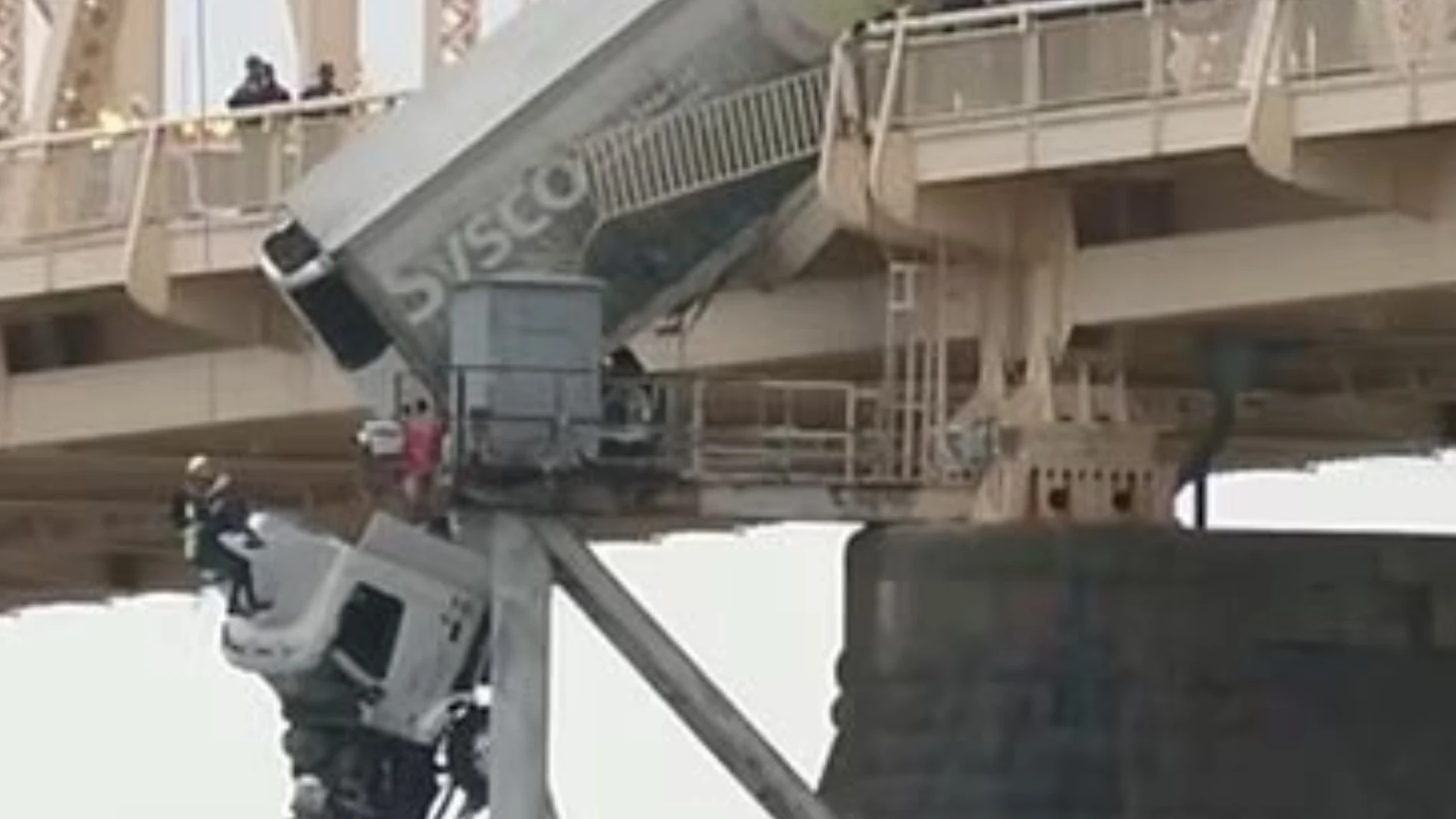 El momento en el que una conductora queda atrapada en un camión que cuelga de un puente