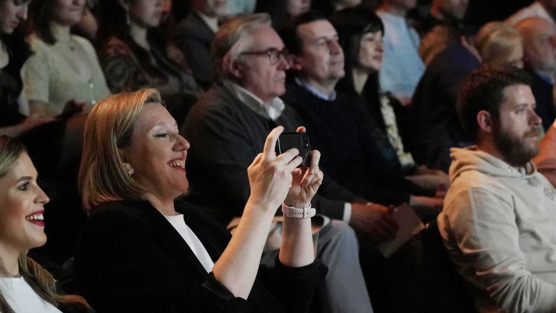 La consejera Isabel Blanco realiza una foto con su móvil durante la gala de arte joven celebrada en Valladolid