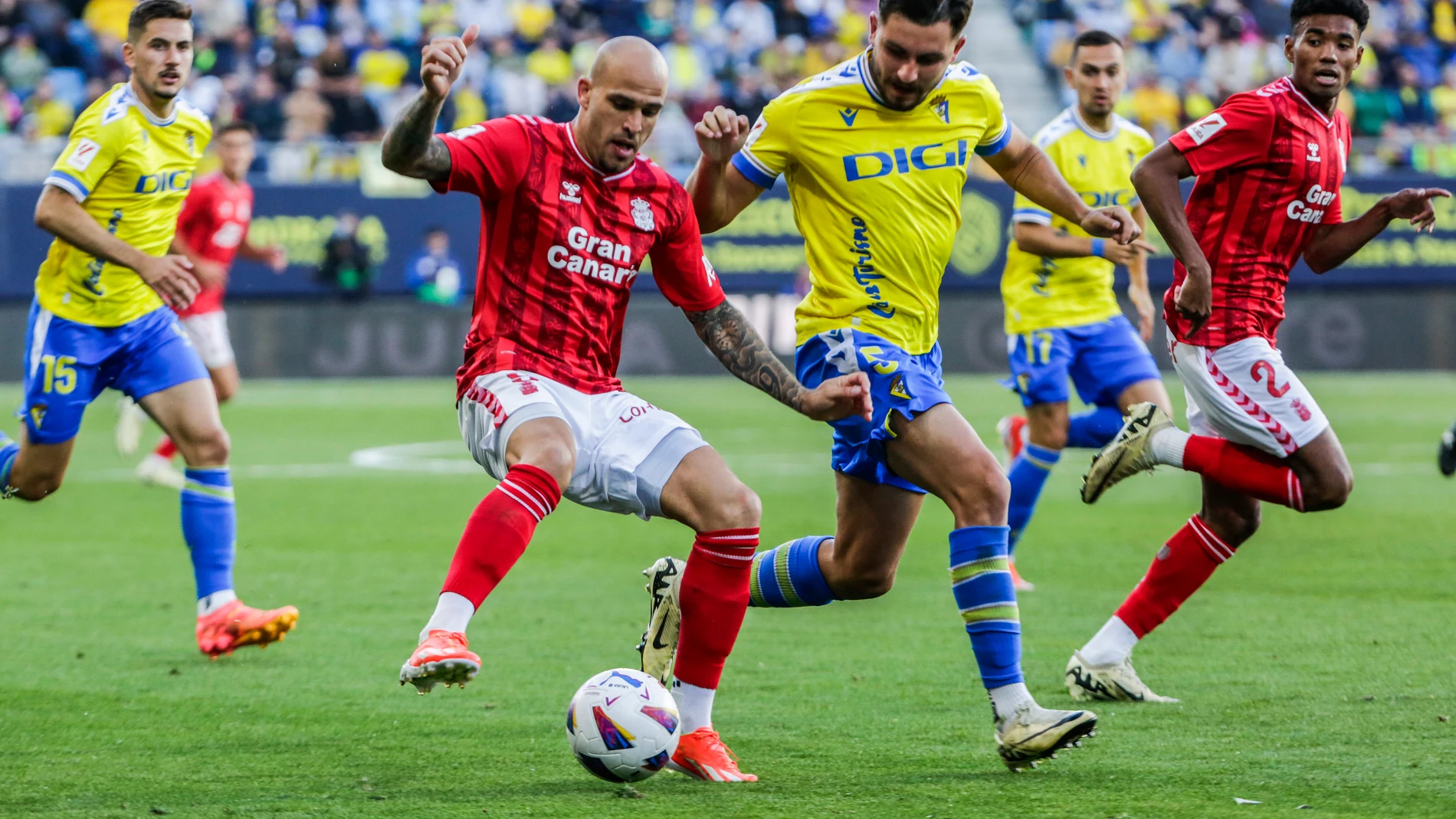 CÁDIZ, 19/05/2024.- El delantero de la UD Las Palmas, Sandro (i), con el balón ante el jugador del Cádiz, Víctor Chust, durante el encuentro correspondiente a la jornada 37 de Primera División que disputan hoy Domingo en el estadio Nuevo Mirandilla. EFE/Román Ríos.