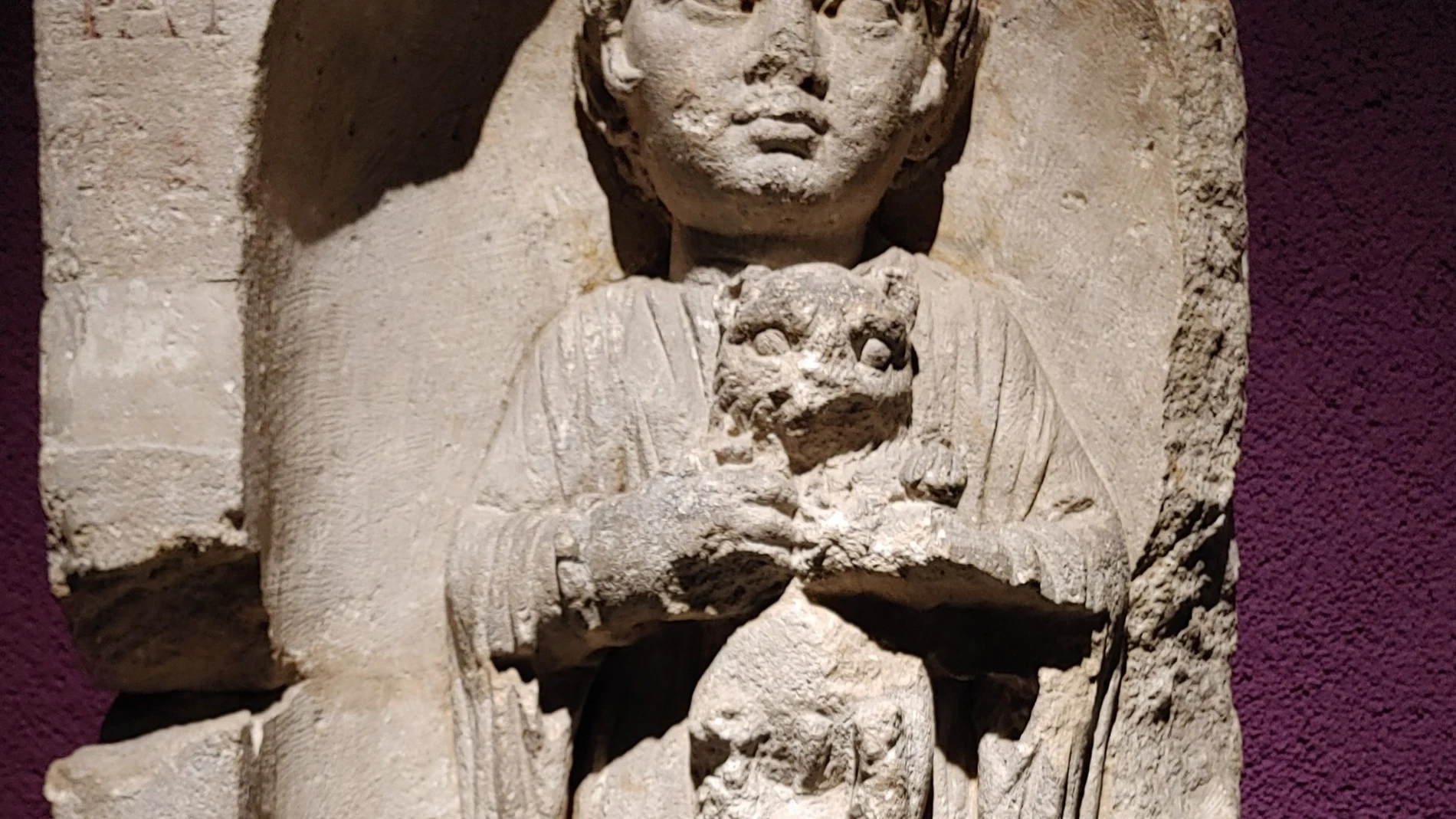 Lápida funeraria romana de una niña que sostiene a un cachorro en el Museo de Aquitania de Burdeos