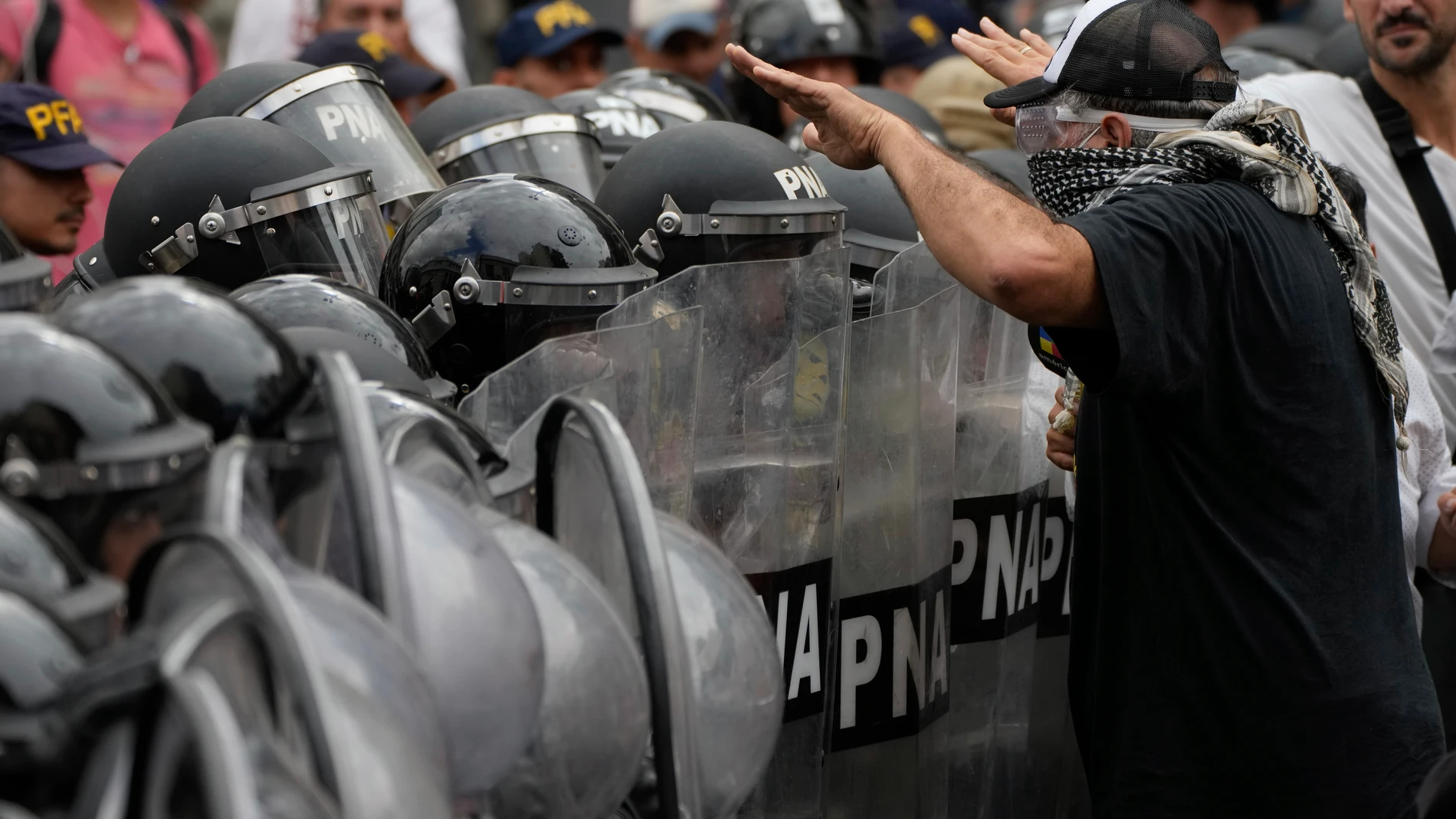 FILE - Eduardo Belliboni, leader of the Polo Obrero political party, stands in front of police during an anti-government protest against food scarcity at soup kitchens and against economic reforms proposed by President Javier Milei in Buenos Aires, Argentina, March 18, 2024. On May 27, 2024, an Argentine judge summoned to testify members of social organizations, including Belliboni, who are suspected of embezzling state funds intended for work programs for the unemployed and coercing their be...