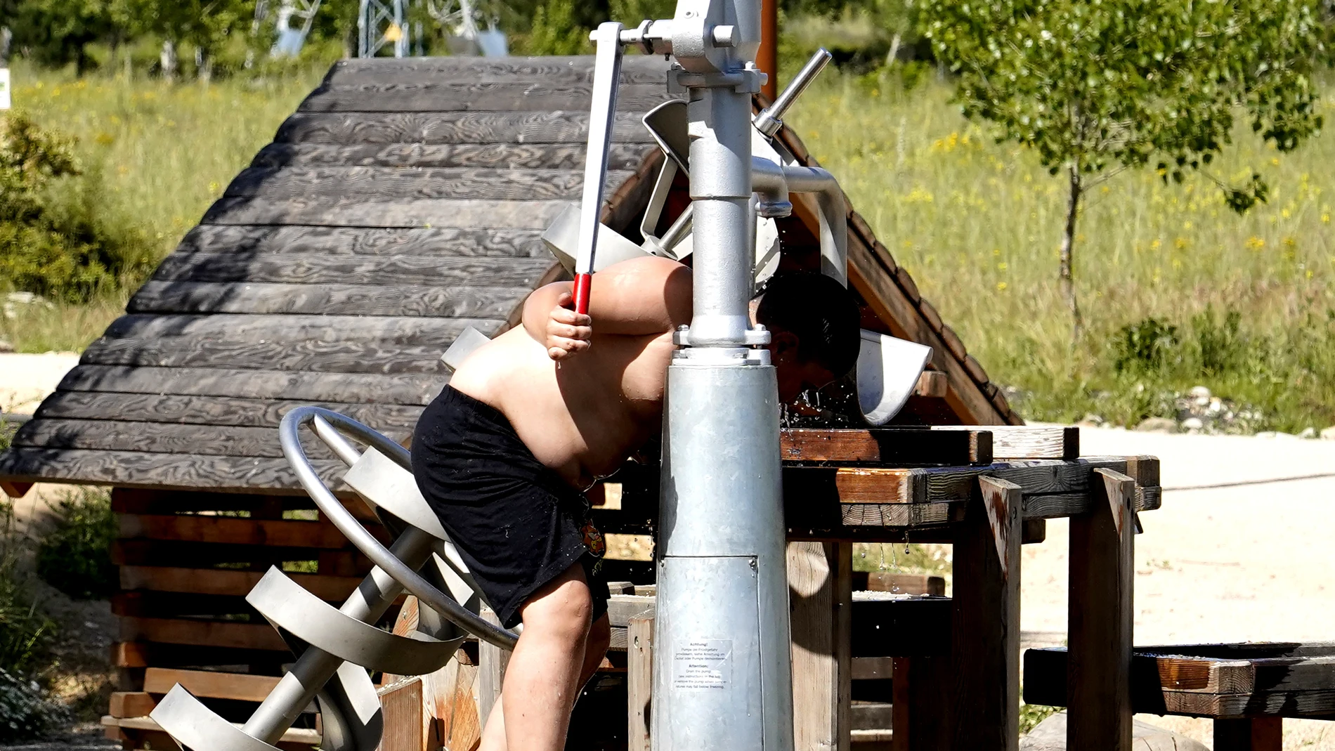 Un joven se refresca ante el intenso calor