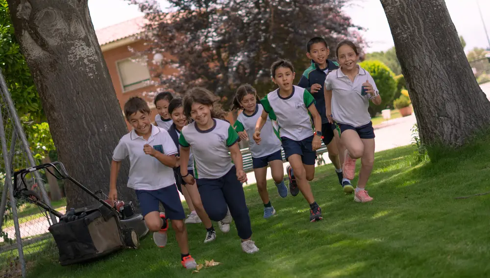 Un grupo de alumnos corre por uno de los patios del colegio