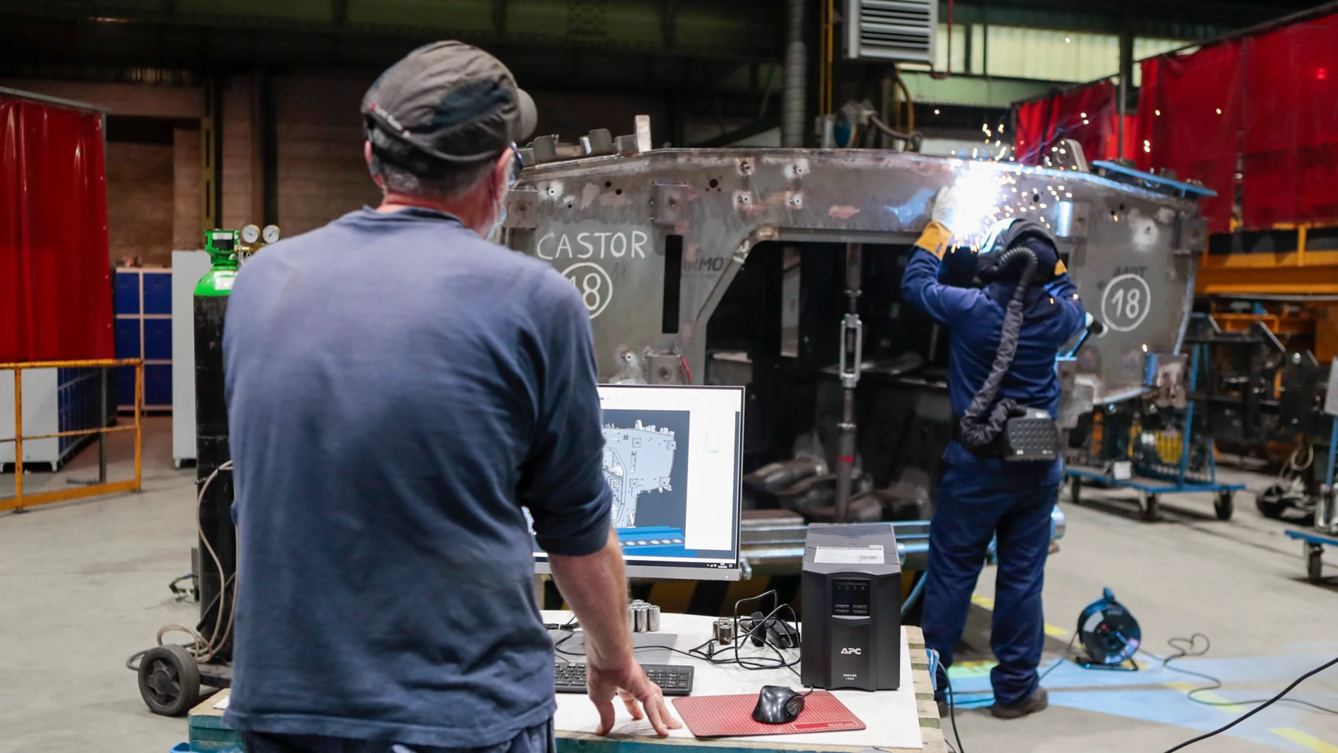 Dos operarios trabajan en la fabricación del blindado "Castor" en la fábrica de Santa Bárbara, en Trubia (Asturias)