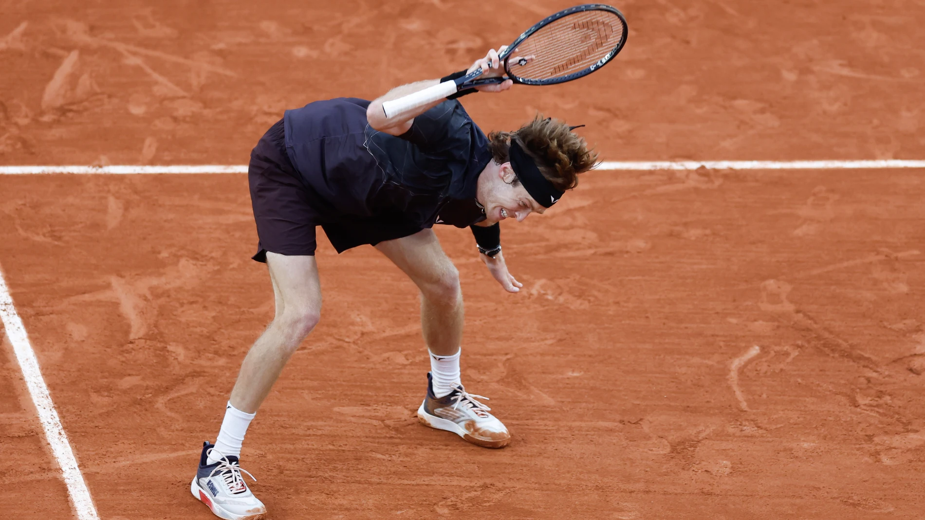 Russia's Andrey Rublev throws his racket on the clay court after missing a shot against Italy's Matteo Arnaldi during their third round match of the French Open tennis tournament at the Roland Garros stadium in Paris, Friday, May 31, 2024. (AP Photo/Jean-Francois Badias)