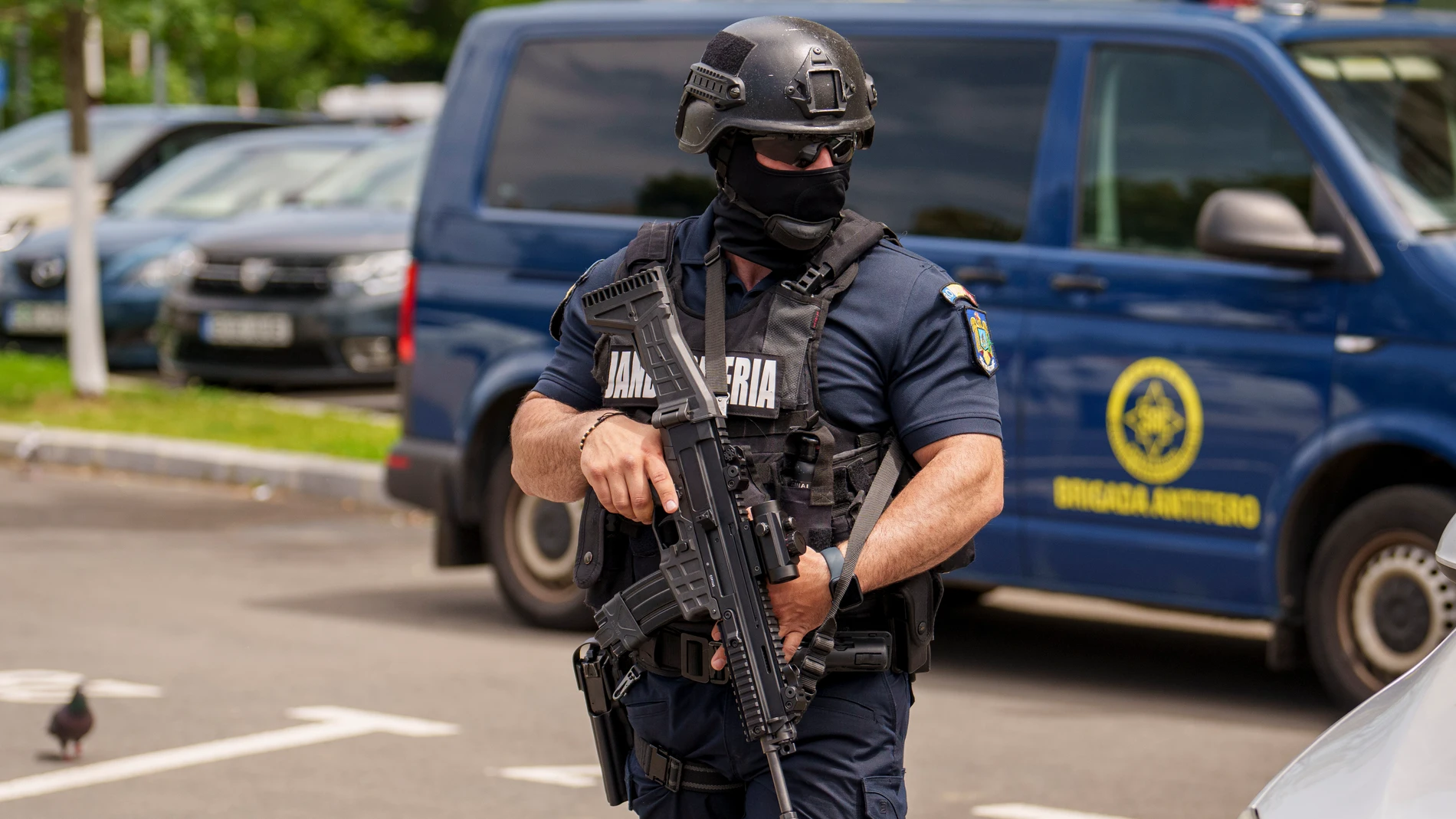 A member of a special unit of the Romanian gendarmerie walks by a van of the anti-terrorist unit of the Romanian Intelligence Service (SRI) outside the apartment block in which the Israeli embassy is located in Bucharest, Romania, Monday, June 3, 2024. A foreign citizen was detained in Romania's capital on Monday after allegedly attacking the entrance of the Israeli Embassy with a Molotov cocktail, causing a small fire but no casualties, local media and police reported. (AP Photo/Vadim Ghirda)