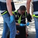 Efectivos de la Policía científica inspeccionan el lugar donde se produjo el tiroteo 