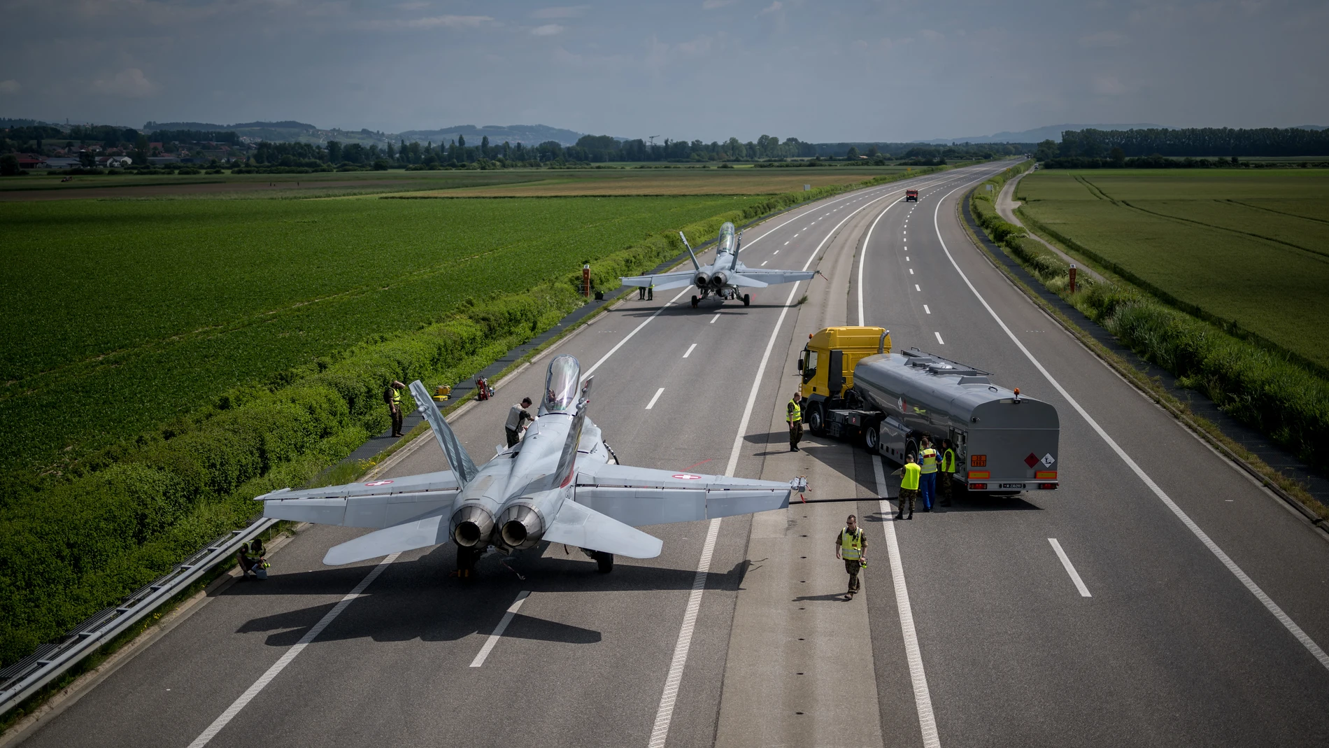 Aviones de combate F/A-18 se reabastecen de combustible durante las pruebas de la Fuerza Aérea Suiza para despegues y aterrizajes de aviones de combate en la autopista A1 entre Avenches y Payerne, Suiza occidental, el 5 de junio de 2024, con el objetivo de probar y ampliar la capacidad de descentralizar sus recursos de defensa aérea