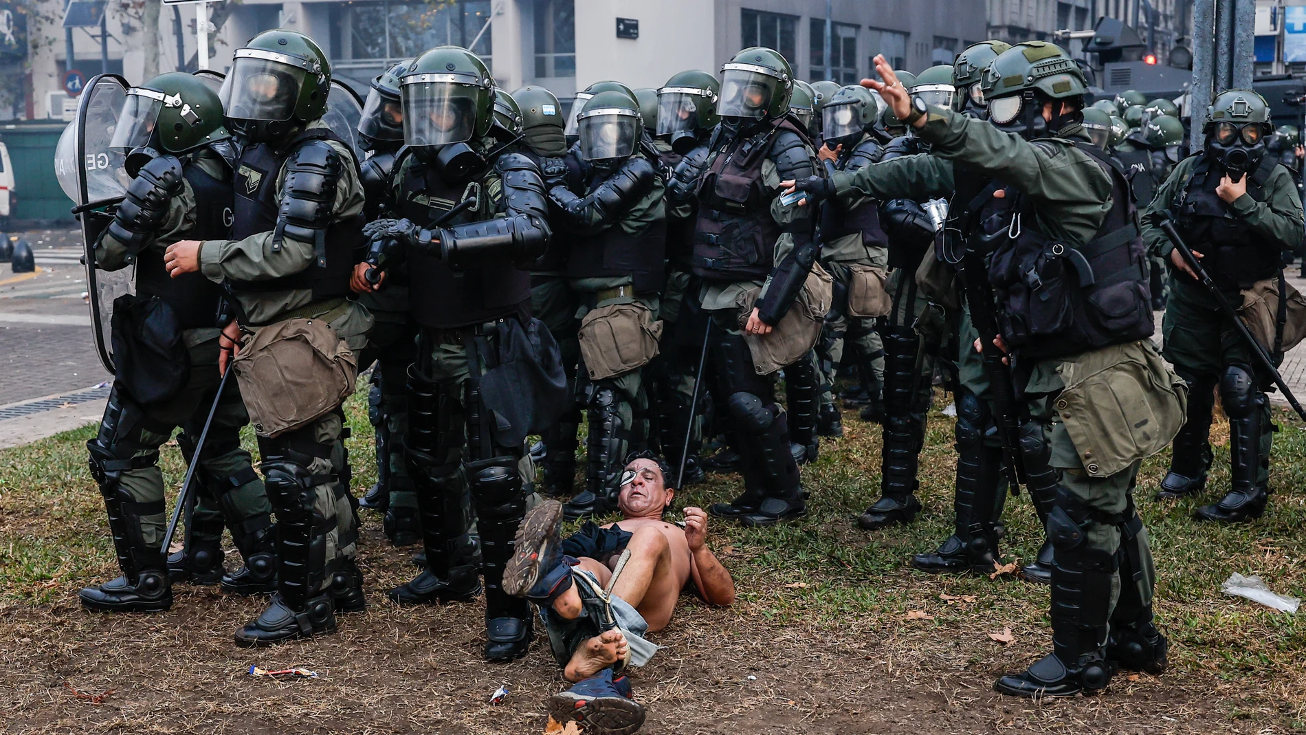 AME3687. BUENOS AIRES (ARGENTINA), 12/06/2024.- Policías detienen a un hombre desnudo durante enfrentamientos entre la policía y personas que protestan a las afueras del senado durante un debate este miércoles, en Buenos Aires (Argentina). Manifestantes y policías protagonizan un choque este miércoles a las puertas del Senado de Argentina mientras la cámara legislativa debate la ley de Bases, el proyecto estrella del Gobierno, con el que el presidente Javier Milei pretende implementar un paqu...