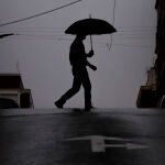  Una persona se protege de la lluvia con un paraguas