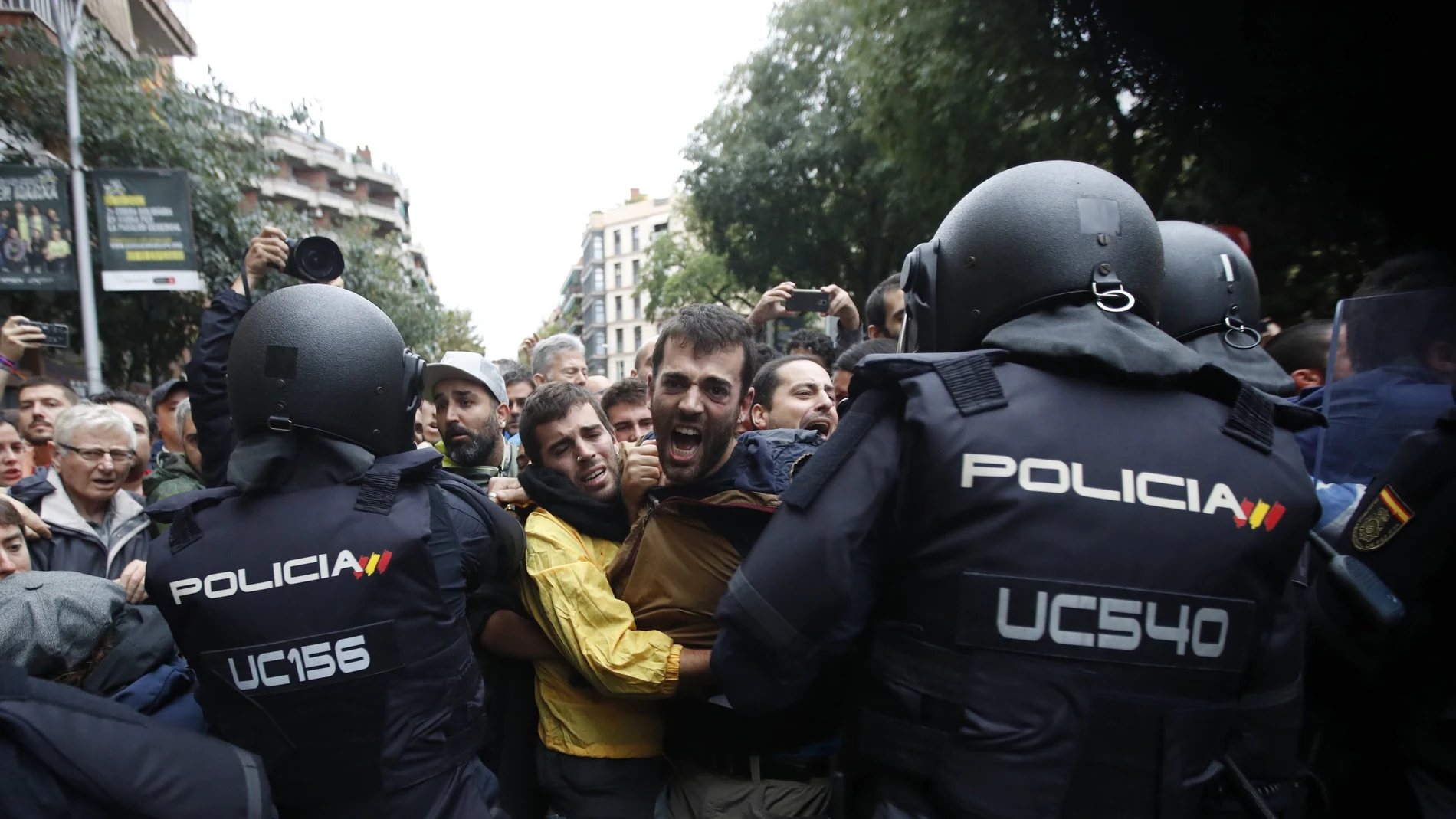 Agentes antidisturbios de la Policía Nacional forman un cordón de seguridad frente al colegio Ramón Llull de Barcelona. Policía Nacional y Guardia Civil han desplegado a sus agentes en varios colegios electorales de Barcelona para impedir el referéndum del 1-O, suspendido por el Tribunal Constitucional (TC).