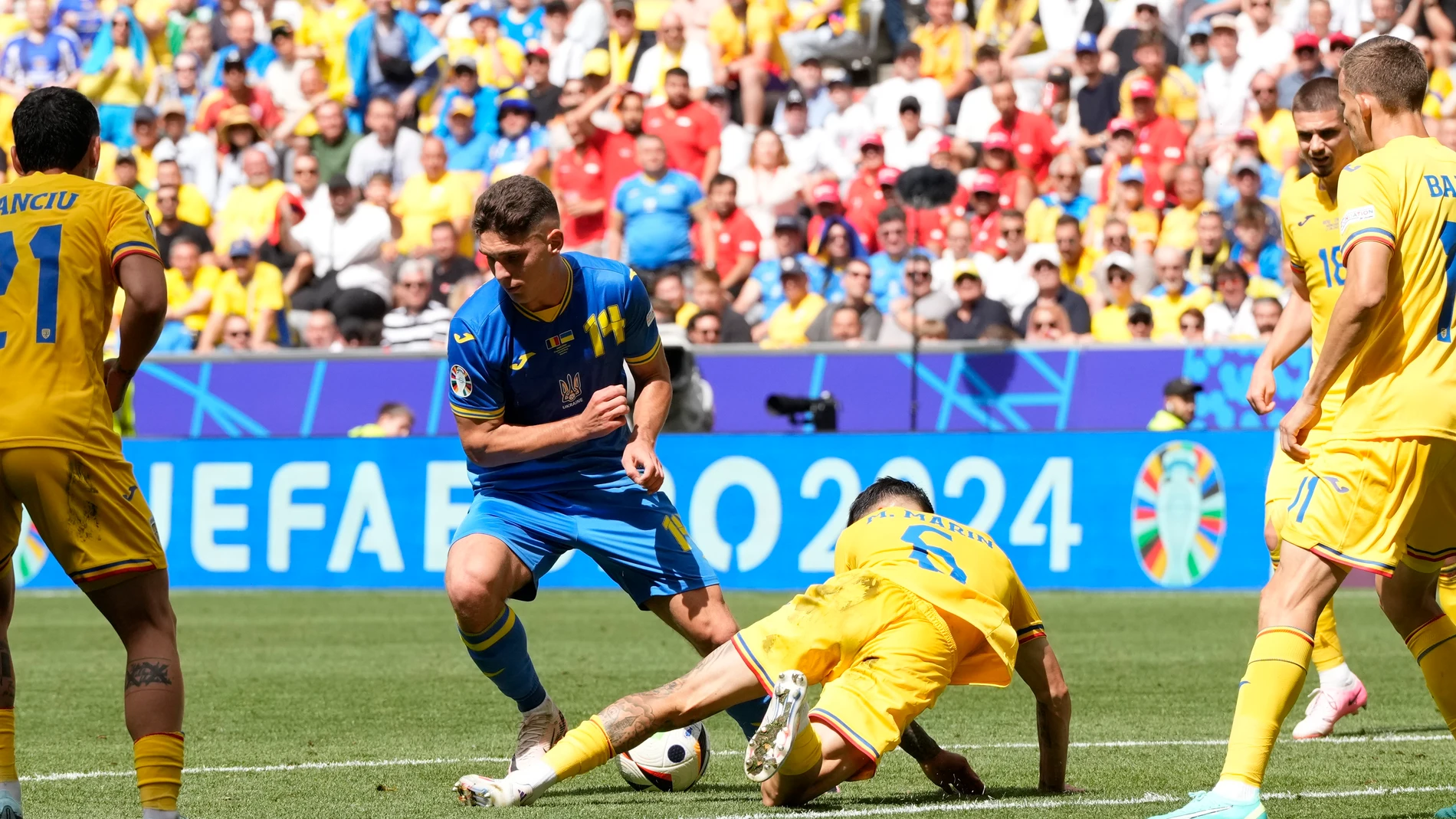 Romania's Marius Marin, bottom, and Ukraine's Heorhiy Sudakov vie for the ball during a Group E match between Romania and Ukraine at the Euro 2024 soccer tournament in Munich, Germany, Monday, June 17, 2024. (AP Photo/Antonio Calanni)