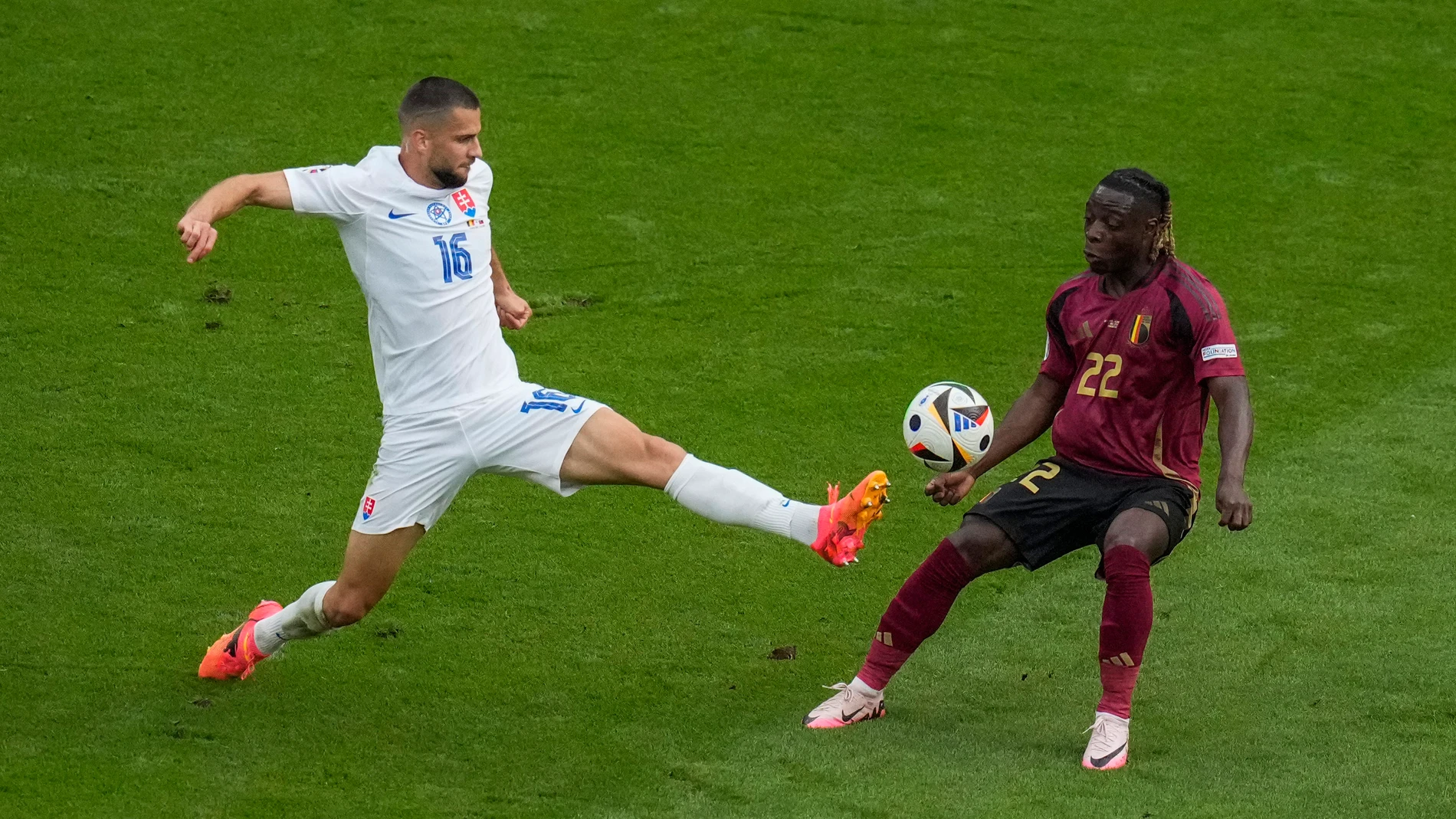 Slovakia's David Hancko, left, lunges for the ball against Belgium's Jeremy Doku during the Group E match between Belgium and Slovakia at the Euro 2024 soccer tournament in Frankfurt, Germany, Monday, June 17, 2024. (AP Photo/Themba Hadebe)