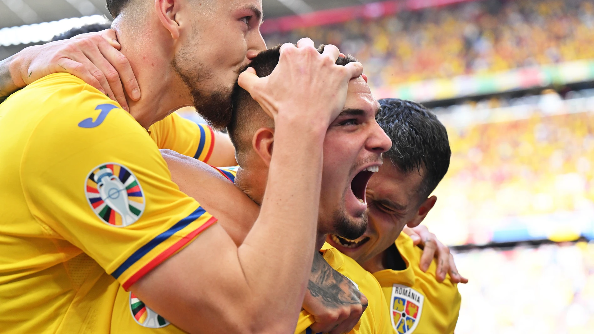 Romania's scorer Razvan Marin, center, and his teammates celebrate their side's second goal during a Group E match between Romania and Ukraine at the Euro 2024 soccer tournament in Munich, Germany, Monday, June 17, 2024. (Peter Kneffel/dpa via AP)