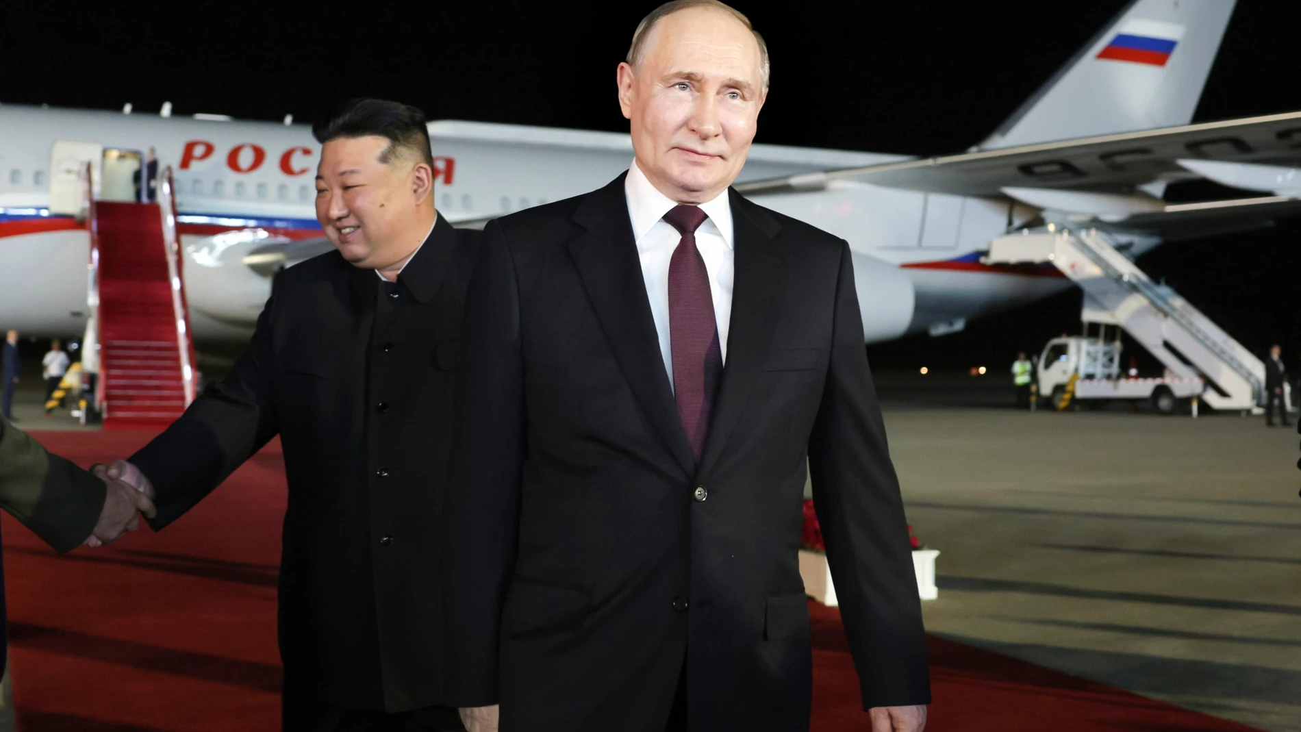 Russian President Vladimir Putin, right, walks as North Korea's leader Kim Jong Un shakes hands with the Russian delegation during their meeting at the Pyongyang Sunan International Airport outside Pyongyang, North Korea, on Tuesday, June 18, 2024. (Gavriil Grigorov, Sputnik, Kremlin Pool Photo via AP)