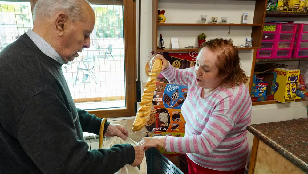 María José Puertas, regente del Bar-centro cultural de La Santa Espina desde 1987, despacha el pan a un vecino