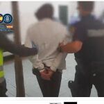 Uno de los detenidos es conducido por la Policía