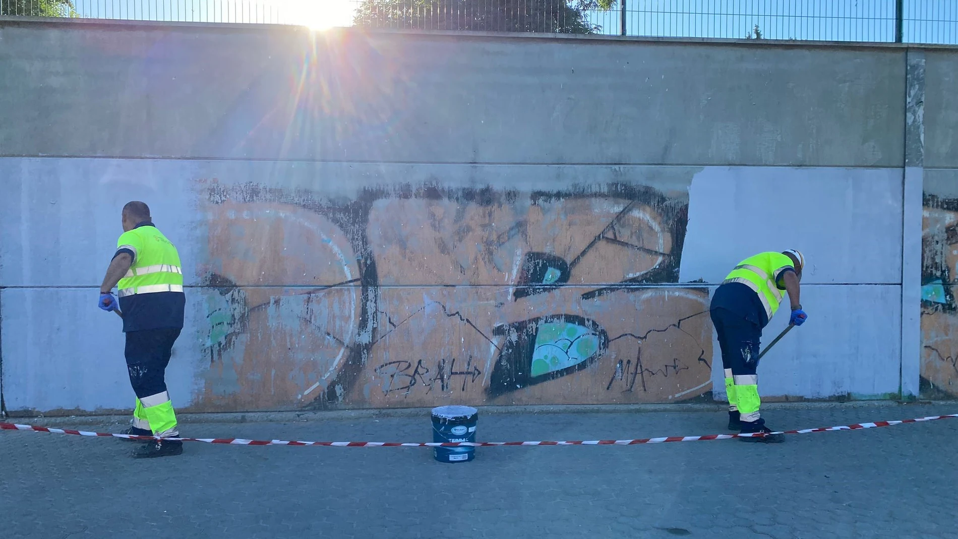 Operarios municipales limpian una pared