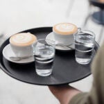 Dos tazas de café y dos vasos de agua