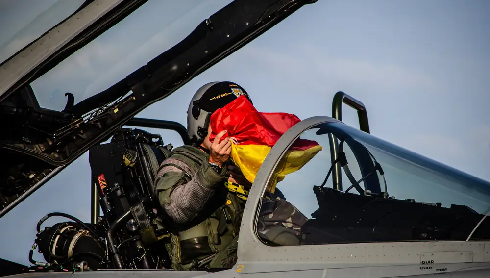 Un piloto sujeta la bandera española en los momentos previos al despegue