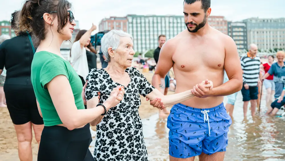 Una de las residentes es ayudada a introducirse en el mar