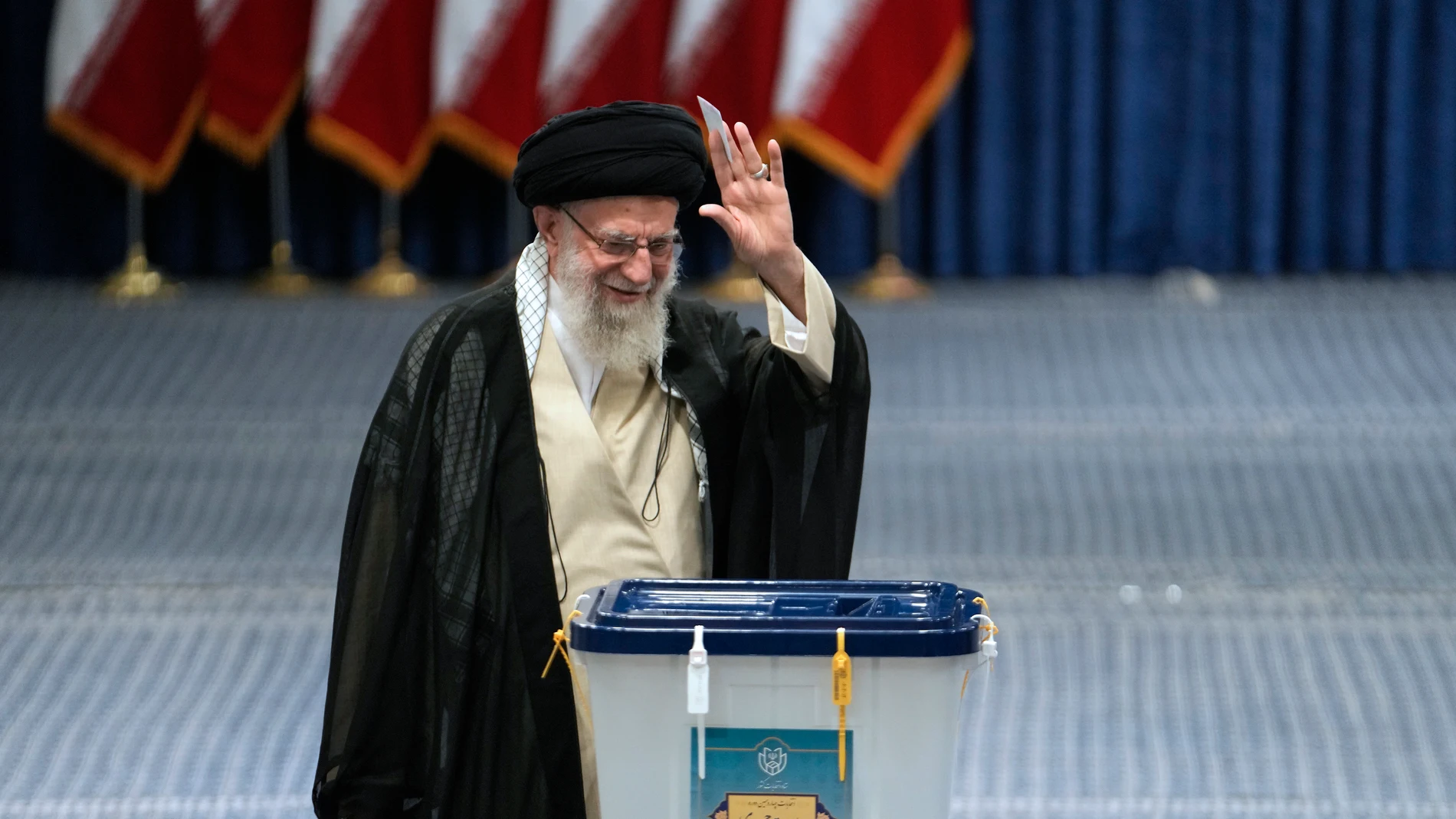 Iranian Supreme Leader Ayatollah Ali Khamenei waves to media before casting his ballot in the presidential election in Tehran, Iran, Friday, June 28, 2024. Iranians voted Friday in a snap election to replace the late hard-line President Ebrahim Raisi, with the race's sole reformist candidate vowing to seek "friendly relations" with the West in an effort to boost his campaign. (AP Photo/Vahid Salemi)