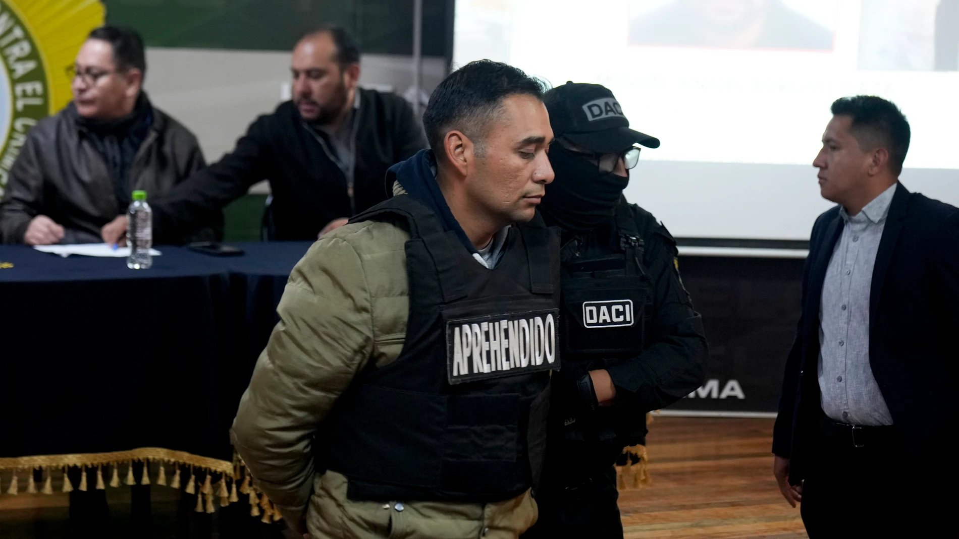 Miguel Angel Burgos is presented to the press in handcuffs by police after his arrest in La Paz, Bolivia, Friday, June 28, 2024. Bolivian government officials said Friday they arrested four more people in connection with Wednesday's failed coup attempt against President Luis Arce, bringing the total detained to 21. (AP Photo/Juan Karita)