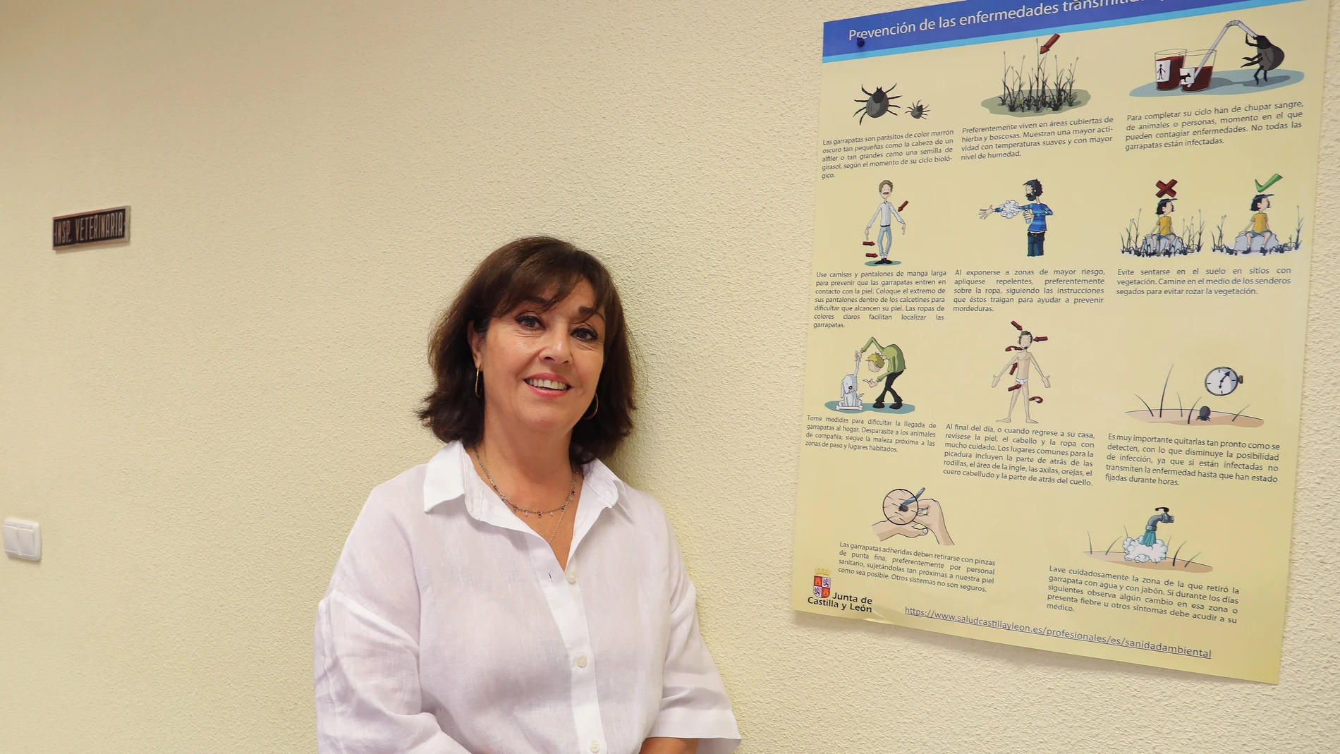 La jefa de la sección de Protección de la Salud, Ana María Ortega, junto a un poster informativo sobre las normas para protejerse de la enfermedades transmitidas por la garrapatas