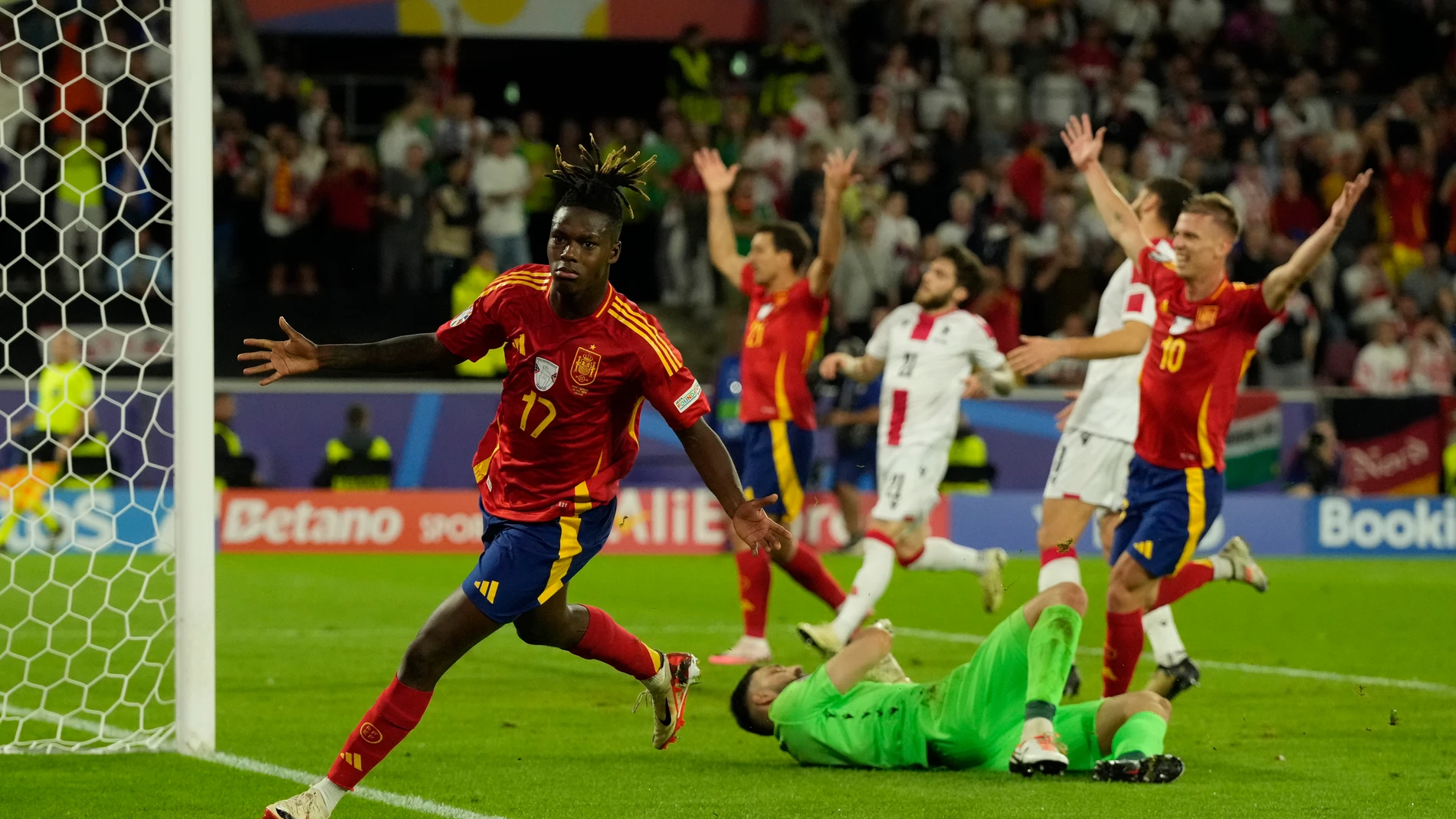 Spain's Nico Williams, left, celebrates after scoring his side's 3rd goal against Georgia during a round of sixteen match at the Euro 2024 soccer tournament in Cologne, Germany, Sunday, June 30, 2024. (AP Photo/Frank Augstein)